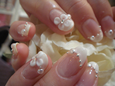 glamourozni nail art sa veštačkim dijamantom i belim cvetićem